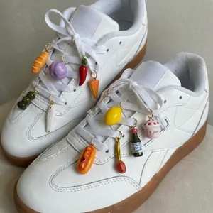 Close-up of colorful food-shaped stainless steel shoe charms on white sneakers laces
