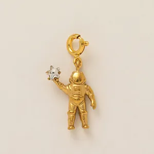 Detailed macro shot of a gold-plated astronaut pendant holding a sparkling star zircon