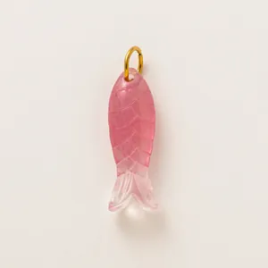 Vista macro di un accessorio fai-da-te a forma di pesce rosa traslucido con anello d'oro