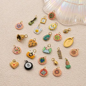 Gros plan de divers breloques en émail coloré en acier inoxydable pour bijoux DIY