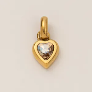 Detailed view of a golden titanium steel heart pendant with faceted clear gemstone center