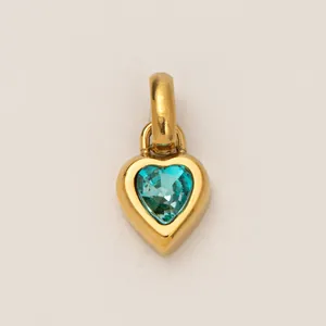 Detailed close-up view of a golden titanium steel heart pendant with teal birthstone