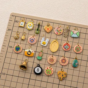 Vue détaillée de divers pendentifs colorés en acier inoxydable sur tapis gradué