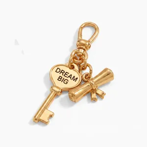 Detailed close-up view of gold-plated heart key and graduation scroll charms for DIY jewelry