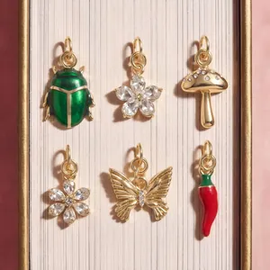 Selection of gold-plated charms including beetle, butterfly, and chili pepper