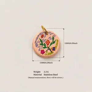 Vue détaillée d'un pendentif floral rond de 15 mm en acier inoxydable plaqué or 18 carats.