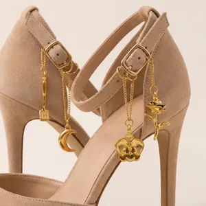 Nahaufnahme von vergoldeten DIY-Schuhanhängern aus Edelstahl an Wildleder-High-Heels