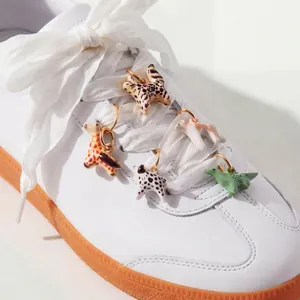 Cute colorful animal shoe charms on white laces featuring cat and dinosaur designs