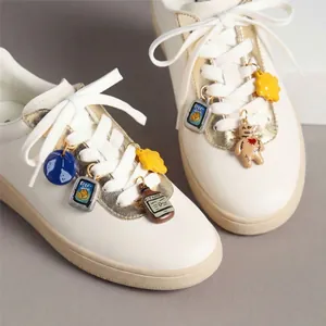 Gros plan de charms de chaussures DIY colorés avec motifs alimentaires sur des lacets.