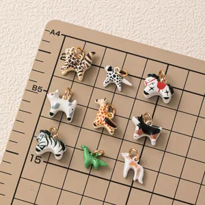 Detailed collection of colorful animal enamel charms displayed on a professional grid mat.