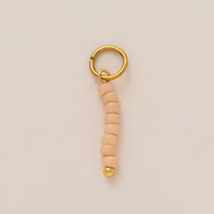 Close-up of handmade beaded shoe charm pendant with gold-plated stainless steel ring.