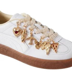Detailed view of DIY 14K gold-plated decorative charms attached to white sneaker laces