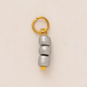 Close-up of stainless steel shoe charm pendant with three textured silver beads