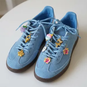 Vue macro détaillée de breloques de chaussures DIY en acier inoxydable sur baskets bleues.