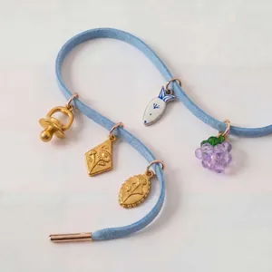 Vue détaillée de charms dorés 18 carats sur cordon en daim bleu pour chaussures