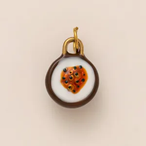 Detailed macro view of a round ceramic food-themed DIY pendant with a glossy finish and gold loop