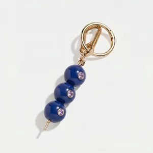 Gedetailleerde weergave van een luxe blauwe kralen hanger voor tas met gouden ring