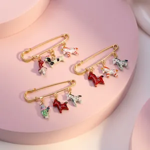 Détail des breloques d'animaux et de champignons peintes à la main sur une broche dorée