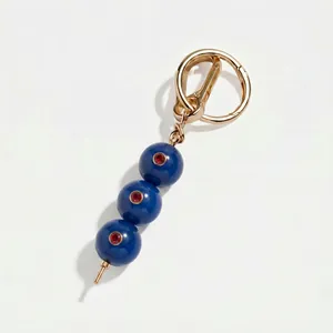 Detail van deze luxe blauwe kralen sleutelhanger met rode stenen en gouden haak