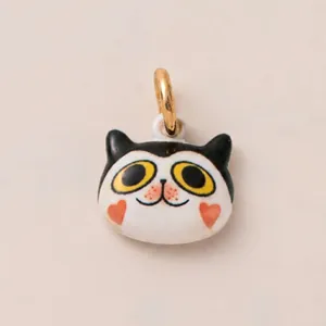 Gros plan d'un pendentif chat de dessin animé avec yeux jaunes et coeurs rouges