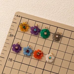 Detail view of colorful flower zircon pendants arranged on a scale measurement mat.