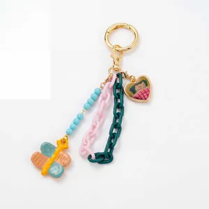 Close-up of a colorful bag charm with butterfly pendant and multi-colored plastic chains