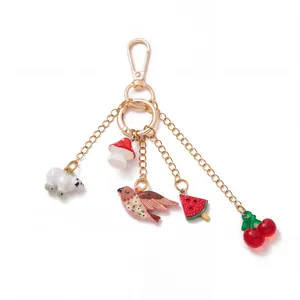 Close-up detail of a vintage style gold bag charm featuring cute panda and fruit pendants
