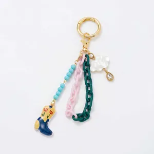 Close-up view of vintage keychain featuring cowboy boot charm and colorful chains