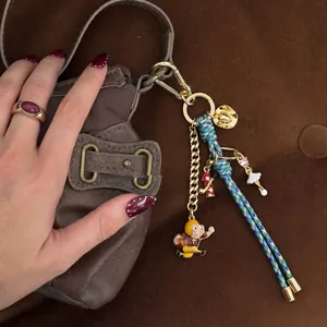 Stylish gold-plated bag charm with woven cord and cartoon athlete pendant for luxury bags