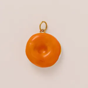 Vue macro d'un pendentif en forme de donut orange glacé pour bijoux DIY