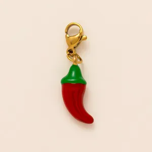 Primo piano di un ciondolo a peperoncino rosso con chiusura dorata per gioielli fai da te