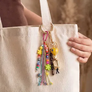 Colorful beaded bag charm with tassel on beige tote bag, boho style accessory