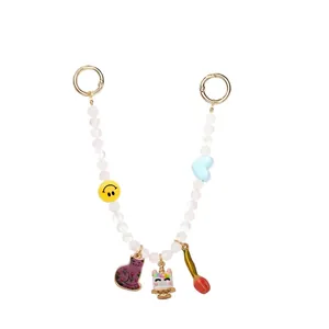 Dettaglio ciondolo borsa con perline e charm di unicorno, gatto e smiley