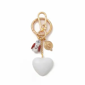 Dettaglio di un portachiavi placcato oro 18 carati con cuore bianco, gufo e ciondolo ape