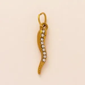 Dettaglio di un ciondolo a forma di peperoncino in acciaio dorato con strass bianchi