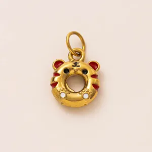 Détail macro d'un pendentif donut en forme de tigre doré avec émail rouge pour bijoux DIY