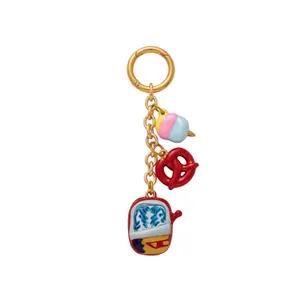 Detailed macro shot of a gold keychain featuring colorful pretzel and can charms