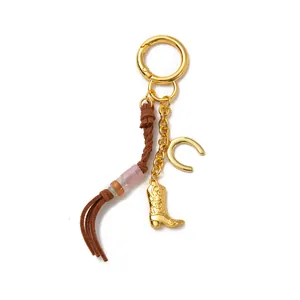 Western style gold keychain featuring horse boot and horseshoe charms with leather tassel