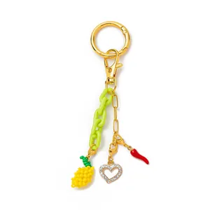 Dettaglio del portachiavi per borsa placcato oro 18K con ciondoli a cuore e peperoncino
