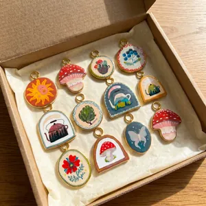 Assorted nature-themed printed titanium steel pendants arranged in a kraft gift box