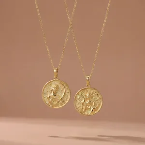Close-up detail of two vintage-style gold goddess coin pendants with high relief textures.