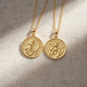Detailed macro view of gold round pendant necklaces with embossed goddess figures.