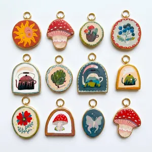 Detailed view of assorted 18K gold plated titanium steel pendants with nature prints.