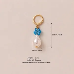 Detailed macro view showing blue flower and baroque pearl pendant with copper material
