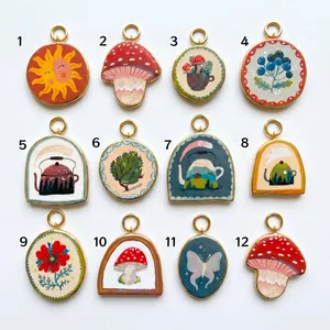 Detailed view of assorted hand-painted 18K gold plated titanium steel pendants in 12 styles