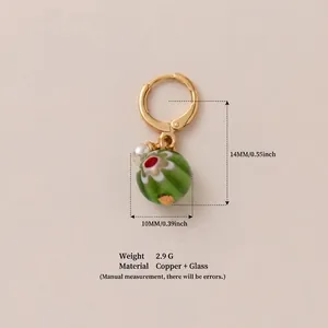 Detail of a 14mm green millefiori glass bead pendant with golden copper hoop