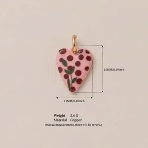 Macro detail of a handmade pink heart pendant with floral and polka dot designs