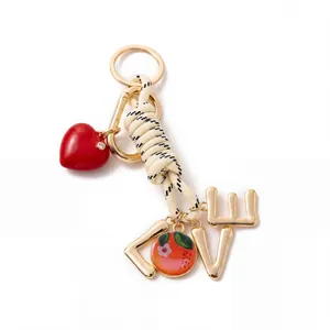Detail view of fashion keychain featuring woven rope, red heart and LOVE charms.