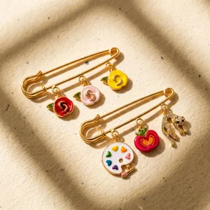 Détail de broches épingles à nourrice dorées avec breloques roses et léopard colorées