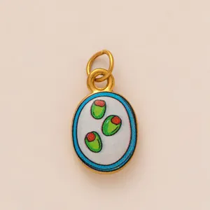 Detailed view of an 18K gold plated stainless steel charm with green olive motif